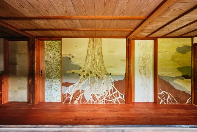 Tableau en papier de Viviane Fontaine, intitulée ”Arbre Mino”, représentant un gilet bleu, agrémenté de dorures dorées, avec au bout de ses manches, une bande dorée